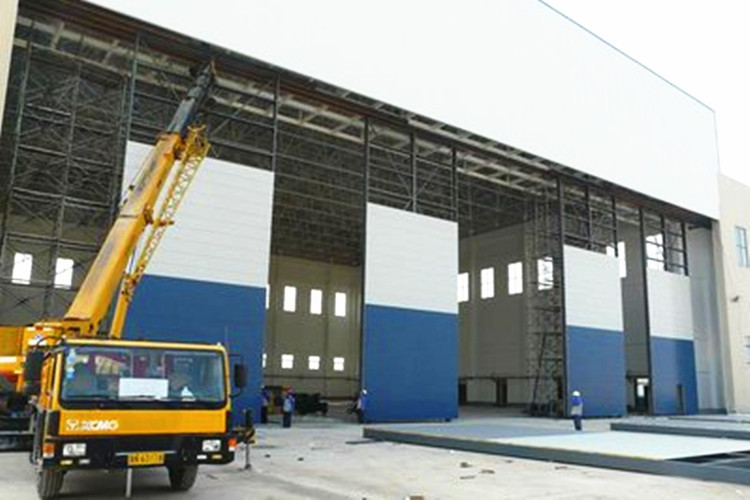 Fabricated steel structure aircraft hangar with wide clear span door opening