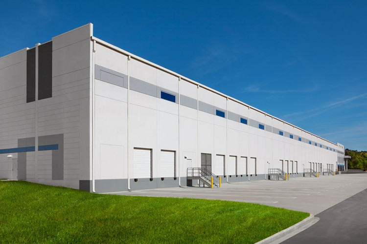 Exterior view of a completed steel structure warehouse with durable corrugated steel sheet roofing and secure access doors
